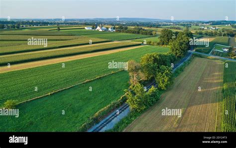 Aerial view of farm lands and corn crop with a train right of way in ...