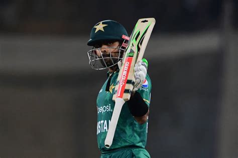 Babar Azam raises his bat after reaching his half-century ...