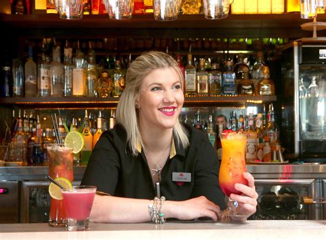 a woman sitting at a bar with drinks in front of her