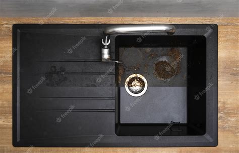 Premium Photo | House cleaning service granite kitchen sink black with leftover bits of food ...