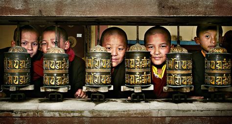 Buddhist Monks In Red Robes Look Out Of The Prayer Wheels With M ...