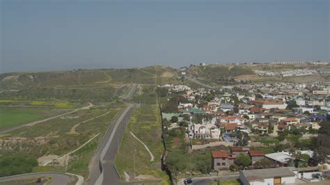 4K stock footage aerial video approach and follow the border fence on the US/Mexico Border ...