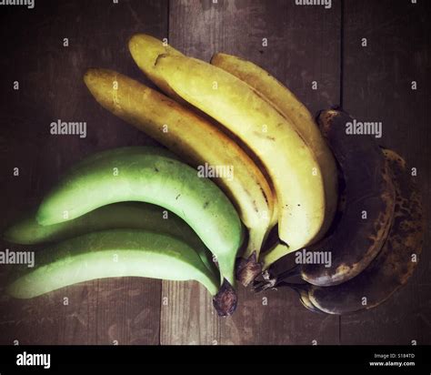 Bananas of different stages of ripening on a wooden surface. Photographed from above Stock Photo ...