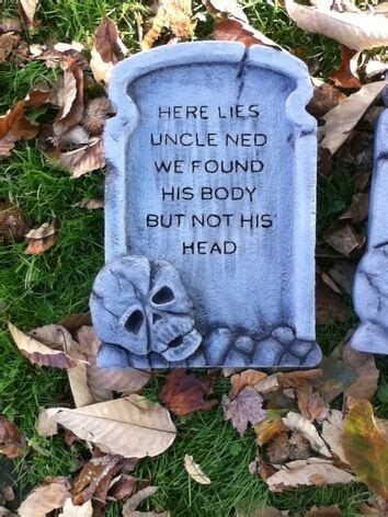 two blue tombstones sitting in the grass with leaves around them and ...