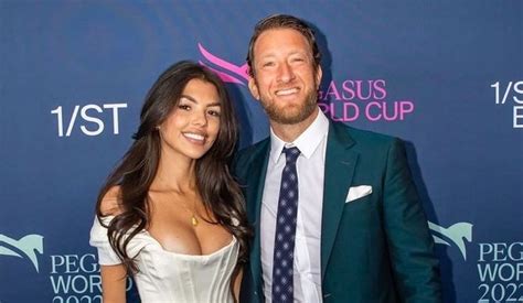 a man and woman standing next to each other on a red carpet in front of ...