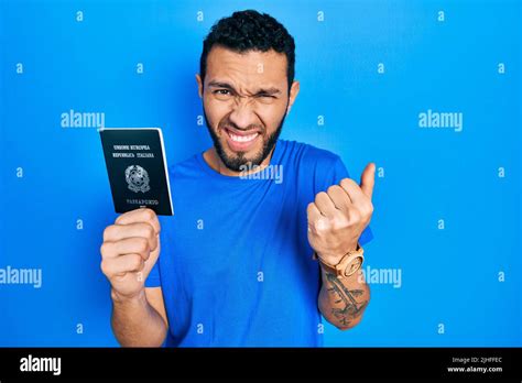 Hispanic man with beard holding italy passport angry and mad raising ...