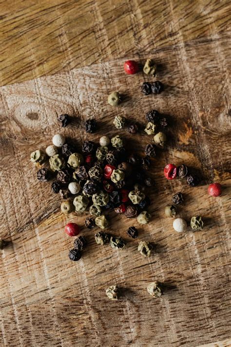 Mix of pepper seeds on wooden surface · Free Stock Photo