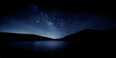 the night sky is lit up with stars above water and mountains in the ...