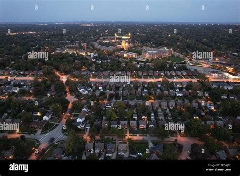 An aerial view of a suburban town at night, illuminated by streetlights ...