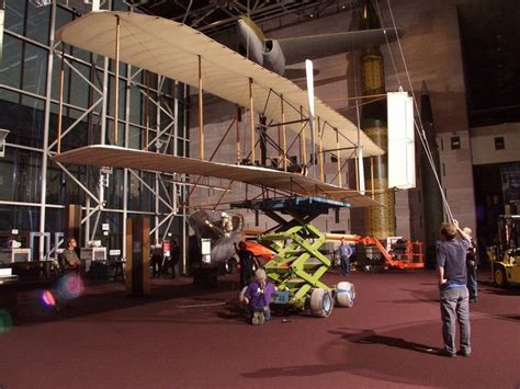 The 1903 Wright Flyer is lowered from its hanging position in the National Air and Space Museum ...