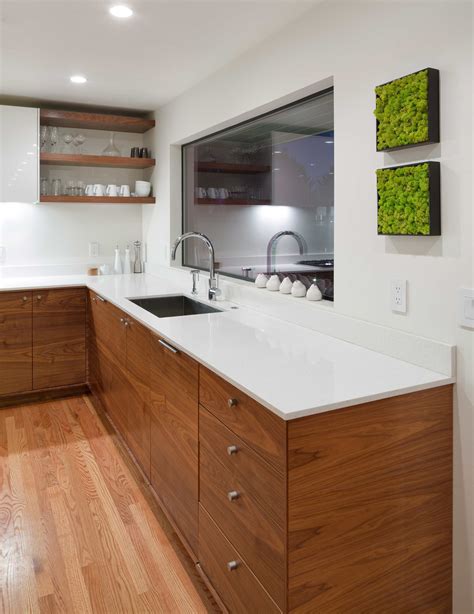 Modern kitchen design/build by Vanillawood. Grain matched walnut cabinetry. White countertops ...