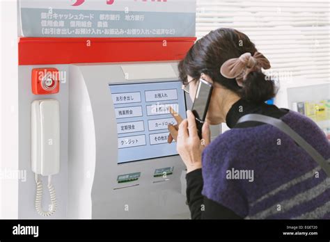 Japanese woman using ATM in a convenience store Stock Photo - Alamy