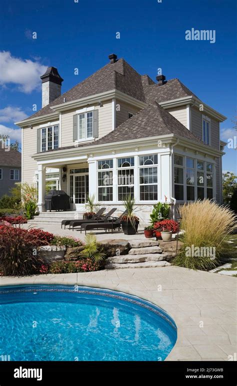 Upscale two-story home with landscaped backyard, patio furniture and in-ground swimming pool ...