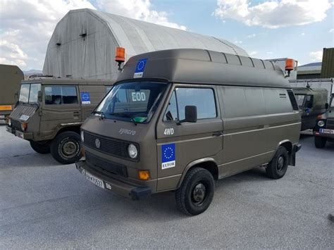 two brown vans parked next to each other in front of a large building with a dome on top