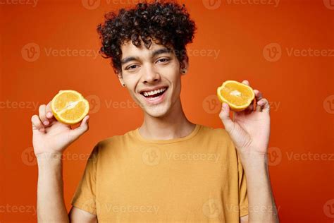 man with curly hair oranges in hands studio isolated background ...