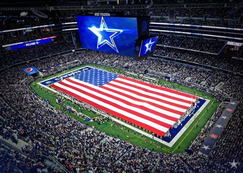 an american flag is displayed in the middle of a football stadium