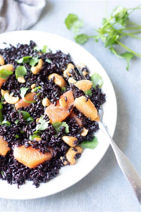 This vegan black rice salad is dressed with an orange juice vinaigrette. It's topped with ...