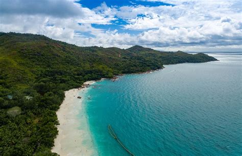 Aerial photography of crystal clear water at shore of Anse Lazio with its granite stone ...