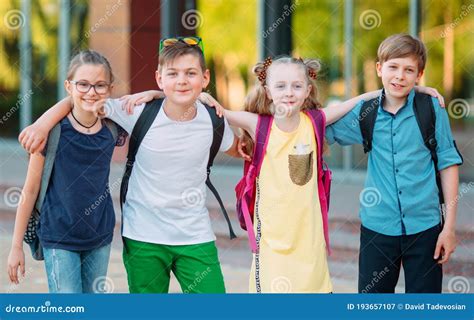 Children`s Friendship. Four Little School Students, Two Boys and Two Girls, Stand in an Embrace ...