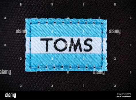 The logo of the brand Toms Shoes as seen as a label stitched on to one of the back of their ...