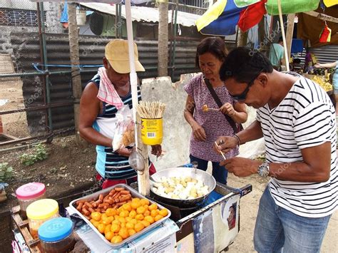 A food vendor cooks fish balls, sausages and quail eggs which he sells ...