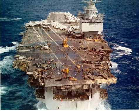 an aircraft carrier is in the middle of the ocean with other ships on ...