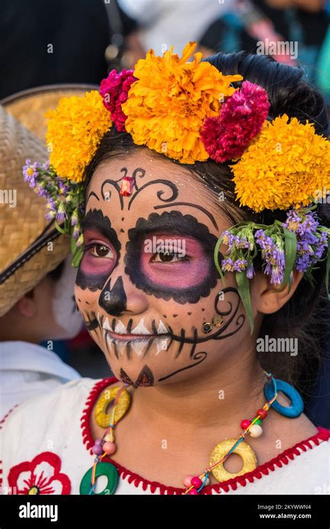 A young girl in costume as La Catrina with face paint for a Day of the Dead children's parade on ...