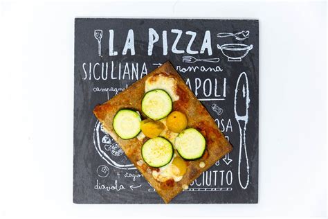 A low carb vegan Pizza from Lizza with yellow cherry tomatoes, vegan cheese and zucchini ...