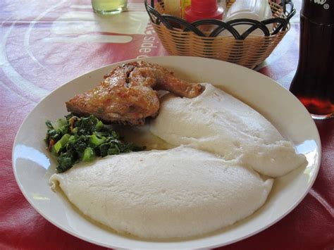 a white plate topped with meat and veggies next to a bottle of beer