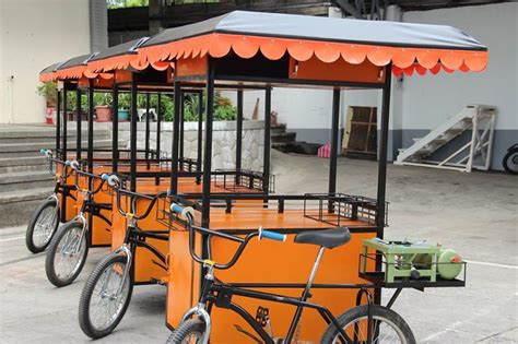 three bicycles are parked in front of an orange cart