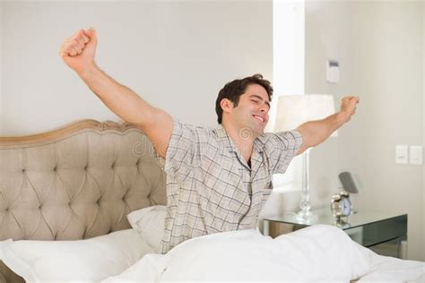 Young Man Waking Up in Bed and Stretching His Arms Stock Photo - Image ...