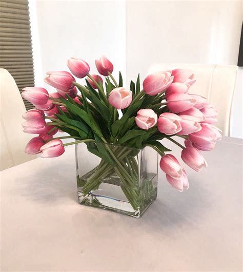 a vase filled with pink tulips on top of a table