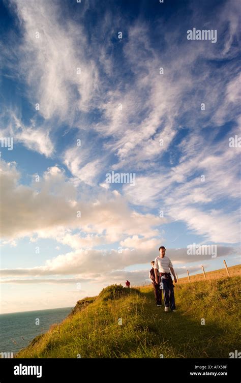 three people walking the Cardigan Bay coastal path Clarach near ...