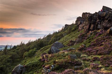 Two People Sit on the Rocks As the Sunset Lights the Heather and Rocks Stock Image - Image of ...