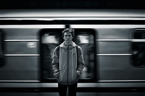 Man Wearing Windbreaker Jacket Standing on Train Station Grayscale Photography · Free Stock Photo