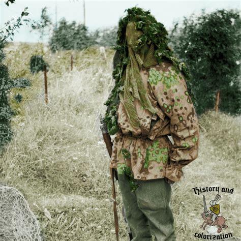 A sniper demonstrates his camouflage (the camo pattern is the Early Plane Tree) at a sniper ...