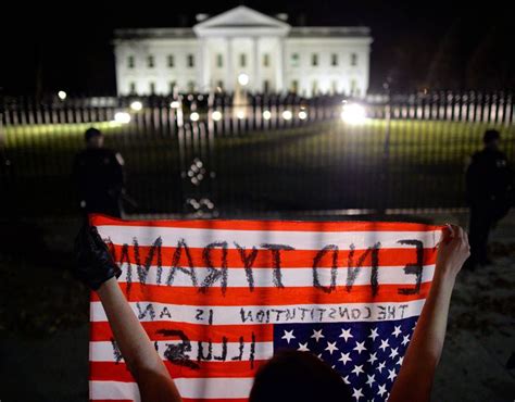 A protester holds an upside down US flag outside The White House | Ferguson Protest - One Year ...