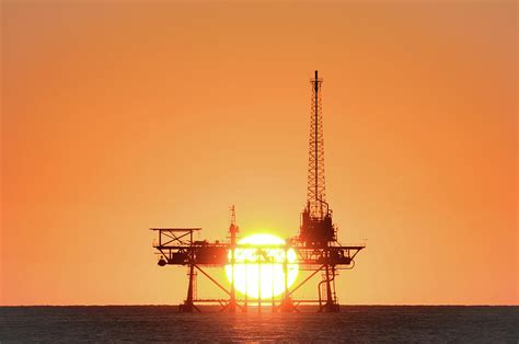 Sunset behind oil rig Photograph by Bradford Martin | Fine Art America