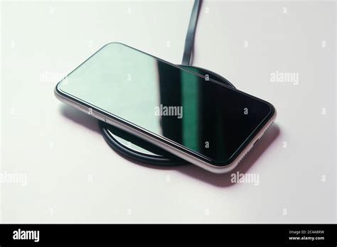 Smartphone charging on a wireless charger Stock Photo - Alamy