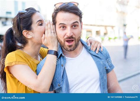 Woman is Whispering a Secret into His Boyfriends Ear Stock Photo ...