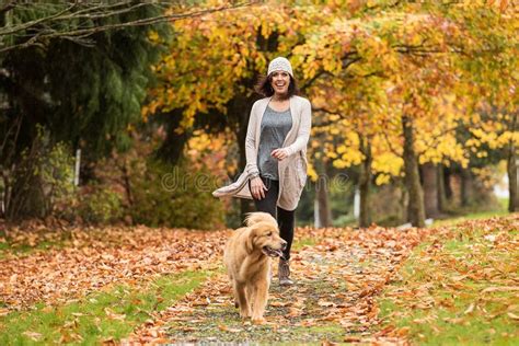 Happy Woman Walking Her Golden Retriever Dog in a Park with Fall Stock Photo - Image of autumn ...