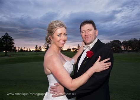 a bride and groom posing for a photo at sunset