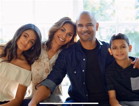 a man, woman and child are sitting on a couch smiling at the camera ...