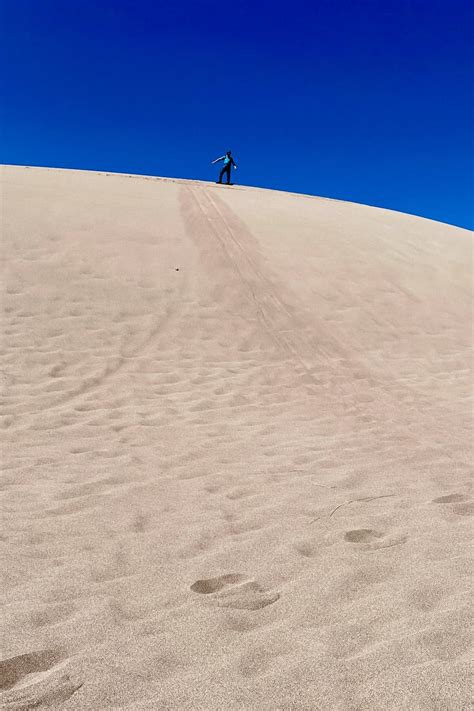 Sandboarding in Colorado (Great Sand Dunes) - Champagne Tastes®