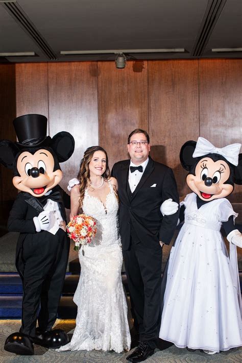 a bride and groom pose with mickey mouses in front of the stage at ...