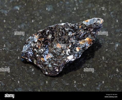 raw obsidian (volcanic glass) stone on dark Stock Photo - Alamy