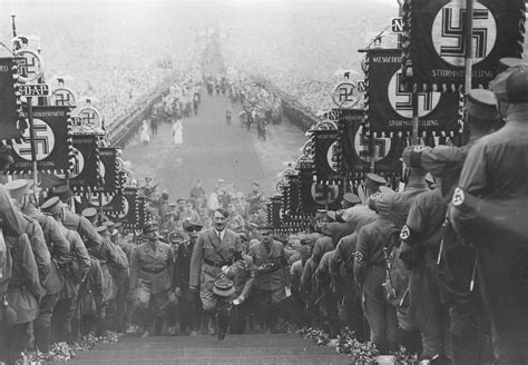 Hitler at the 1935 Nuremberg Rally, walking up the steps to the podium from where he will make ...