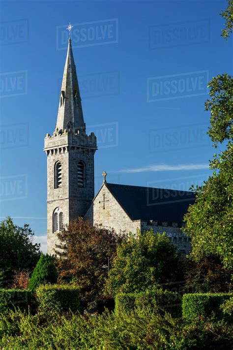 Old stone church steeple with blue sky; Kilrush, County Clare, Ireland - Stock Photo - Dissolve