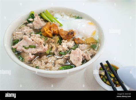 Simple Chinese pork noodle soup with eggs served with lard and chili ...