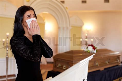 woman with coffin crying at funeral in church | Stock image | Colourbox